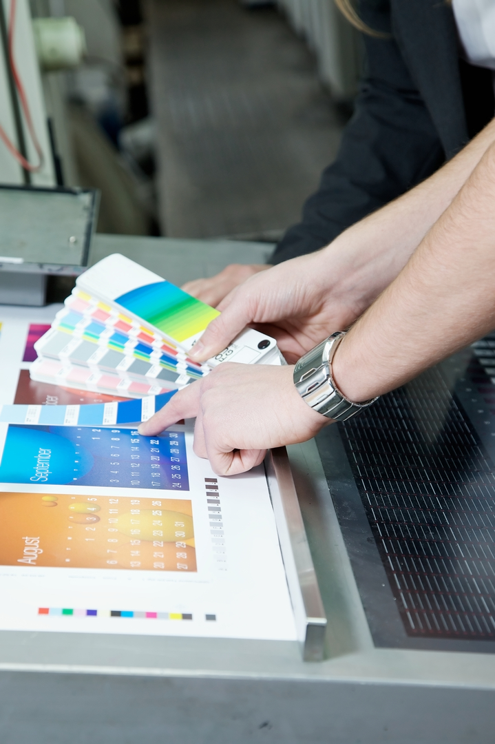 A printing expert compares color swatches to printed colors