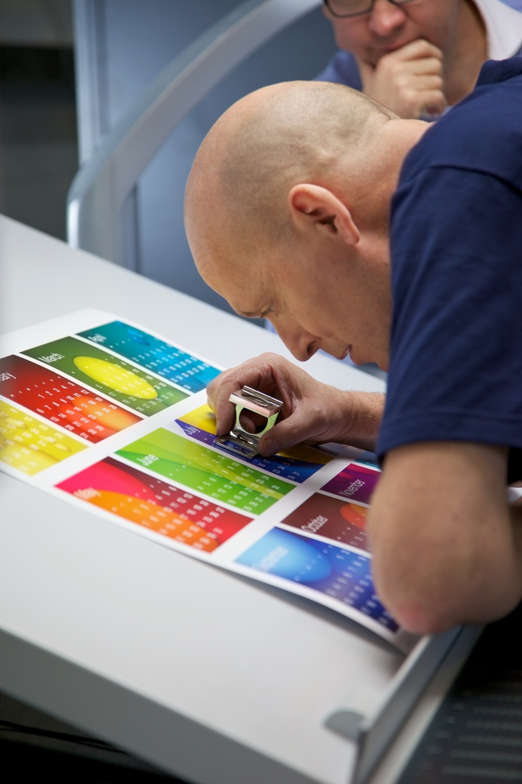 A printing expert scrutinizes a fresh print for excellence